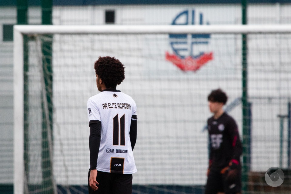 AR Elite Academy number 11 in front of the Bolton Wanderers goal with the club crest behind